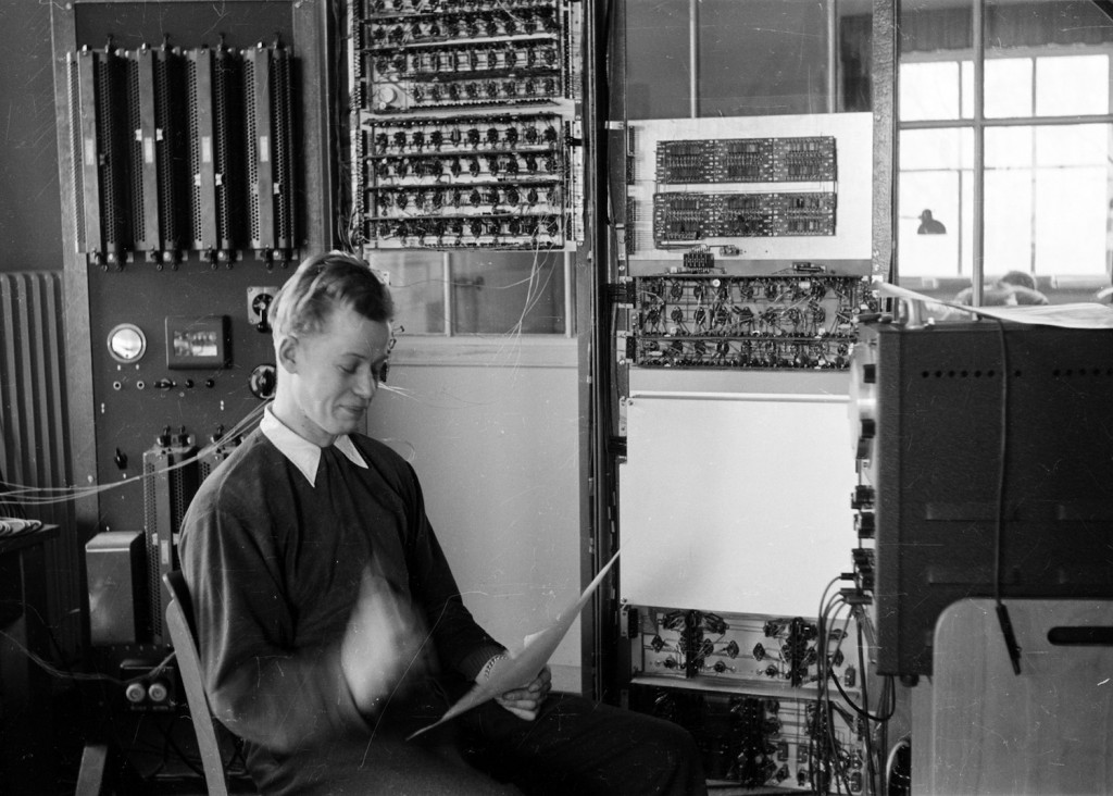 Nuori mies istuu ja tutkii piirustukia.