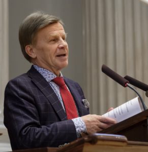 Mies ppitää puhetta.