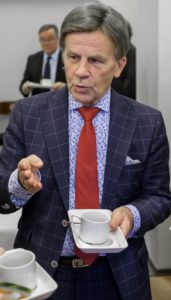 Mies kahvikuppi kädessä.