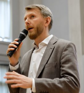 Mies puhuu mikrofoniin.